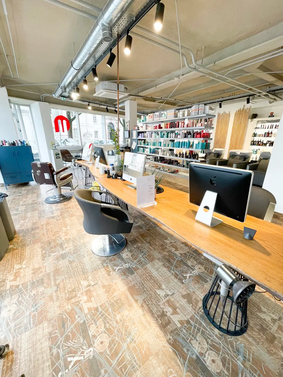 Le salon Minelle, 70 rue de Zurich a Strasbourg : la grande table en bois, le mur de produits et la vitrine